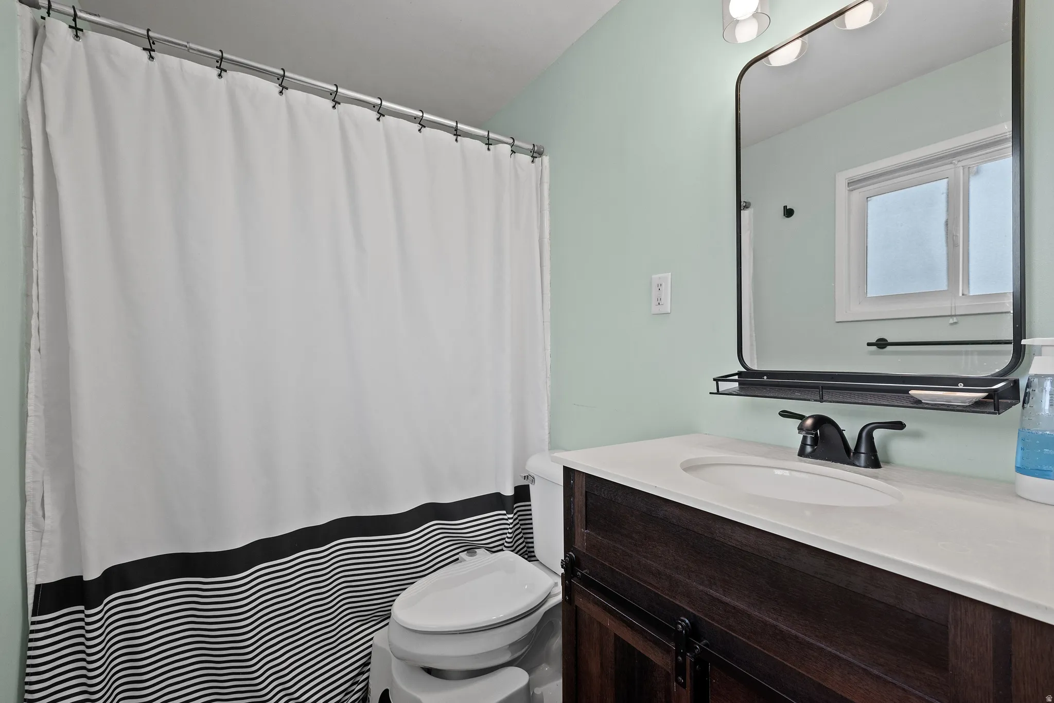 Bathroom featuring a dark wood-finish vanity with a white countertop and integrated sink