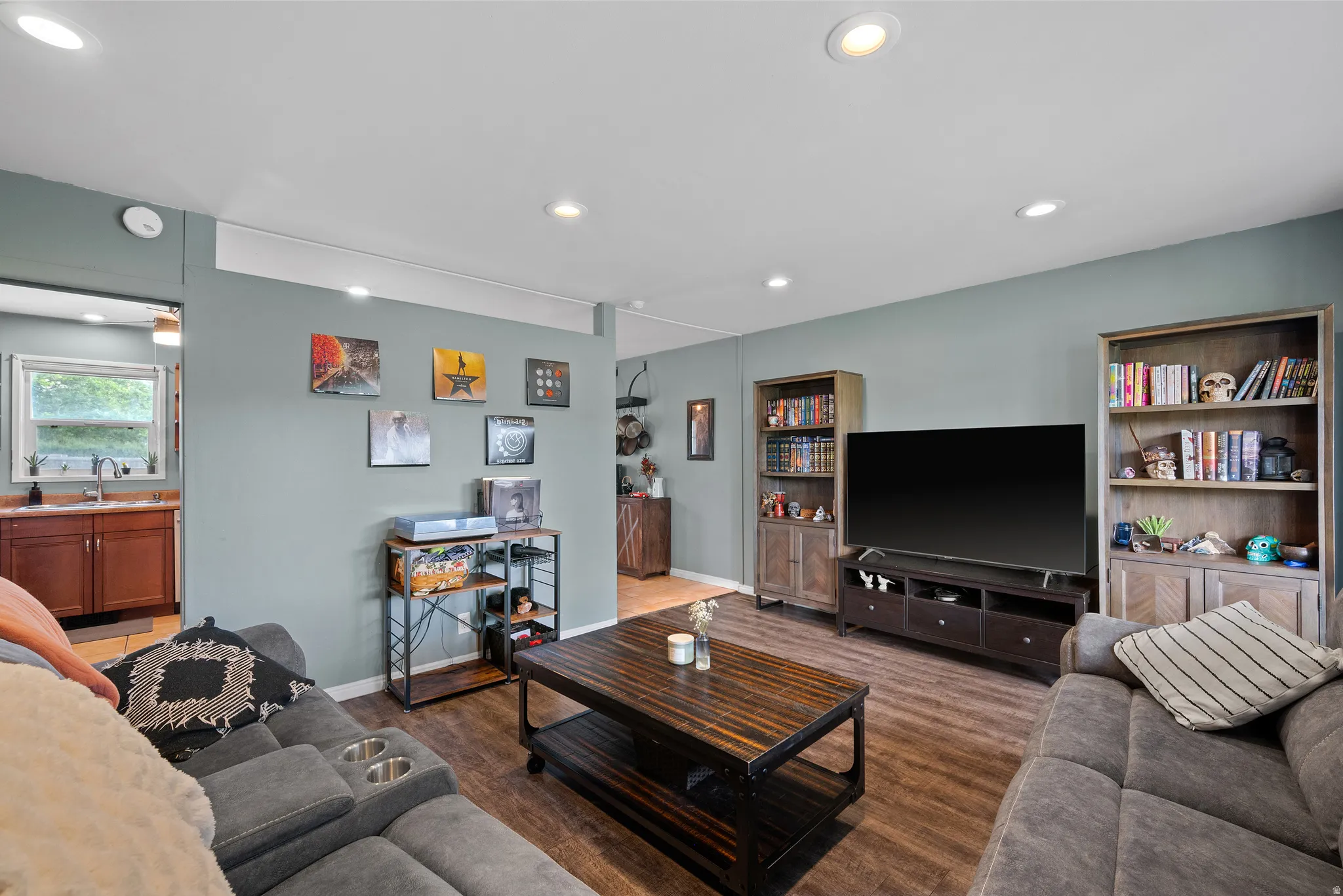 Living area featuring recessed lighting, wood-finish flooring, and built-in shelving units