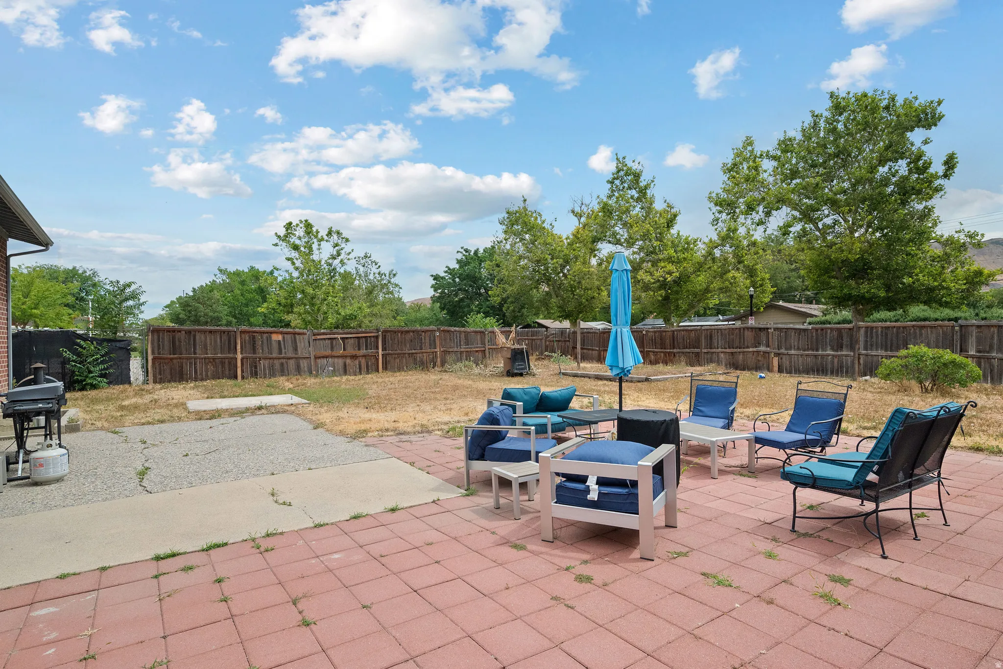 Spacious backyard featuring a brick paver patio, secondary concrete patio, and wood privacy fencing