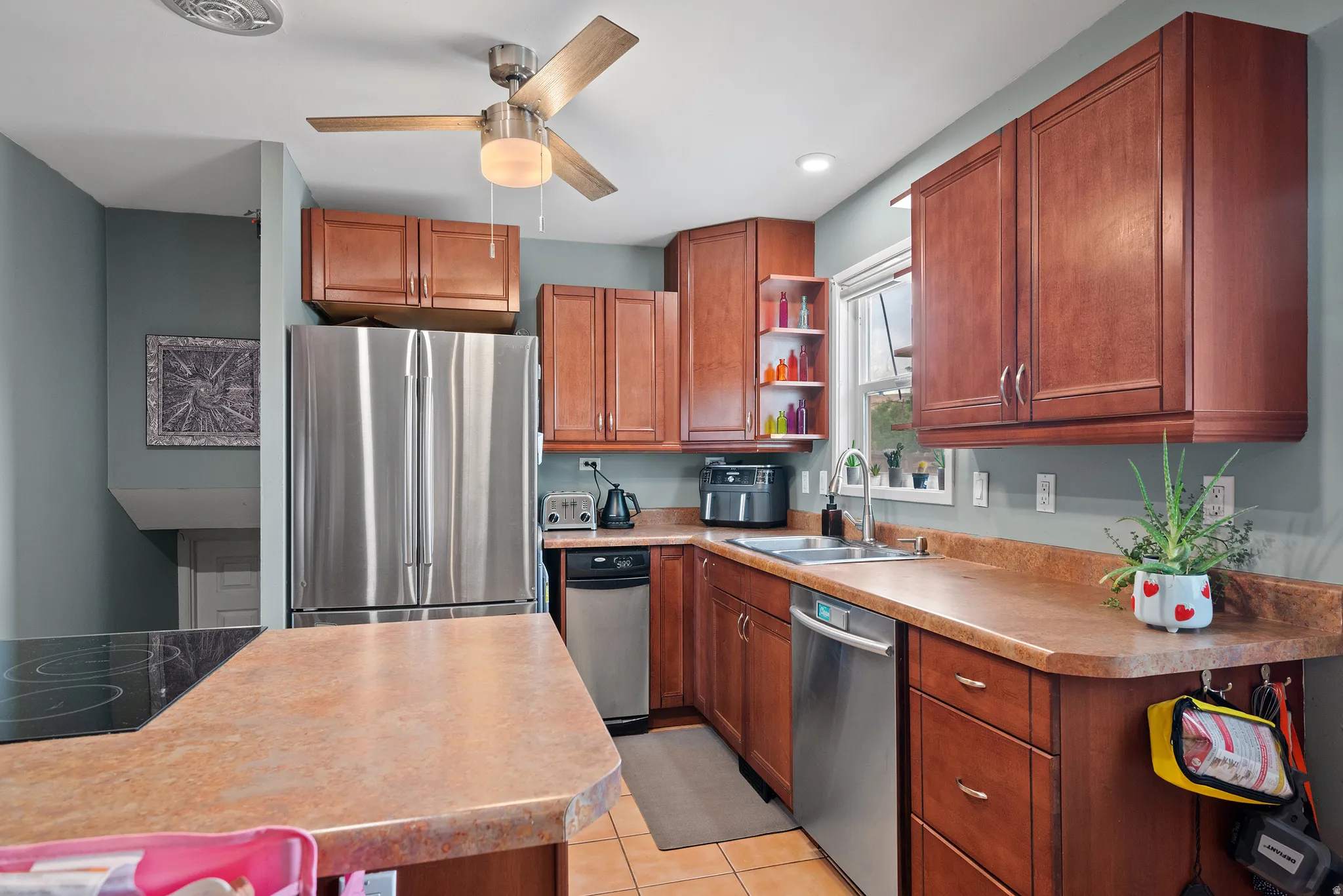 Kitchen featuring wood-finish cabinetry, stainless steel appliances, and a composite countertop