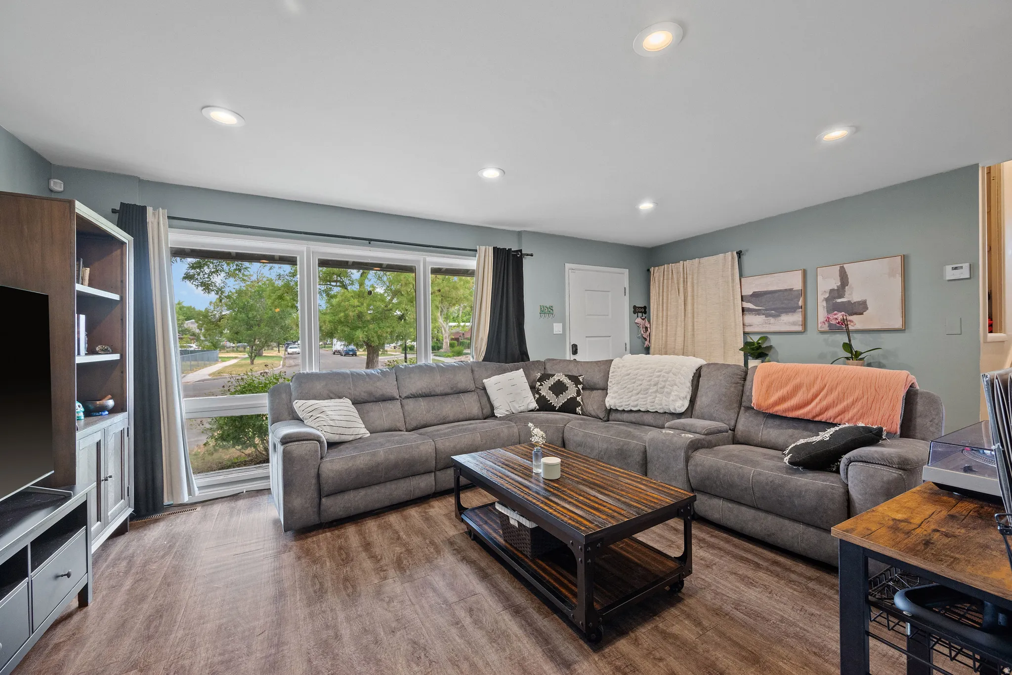 Living area featuring wood-finish flooring, recessed lighting, and a large picture window