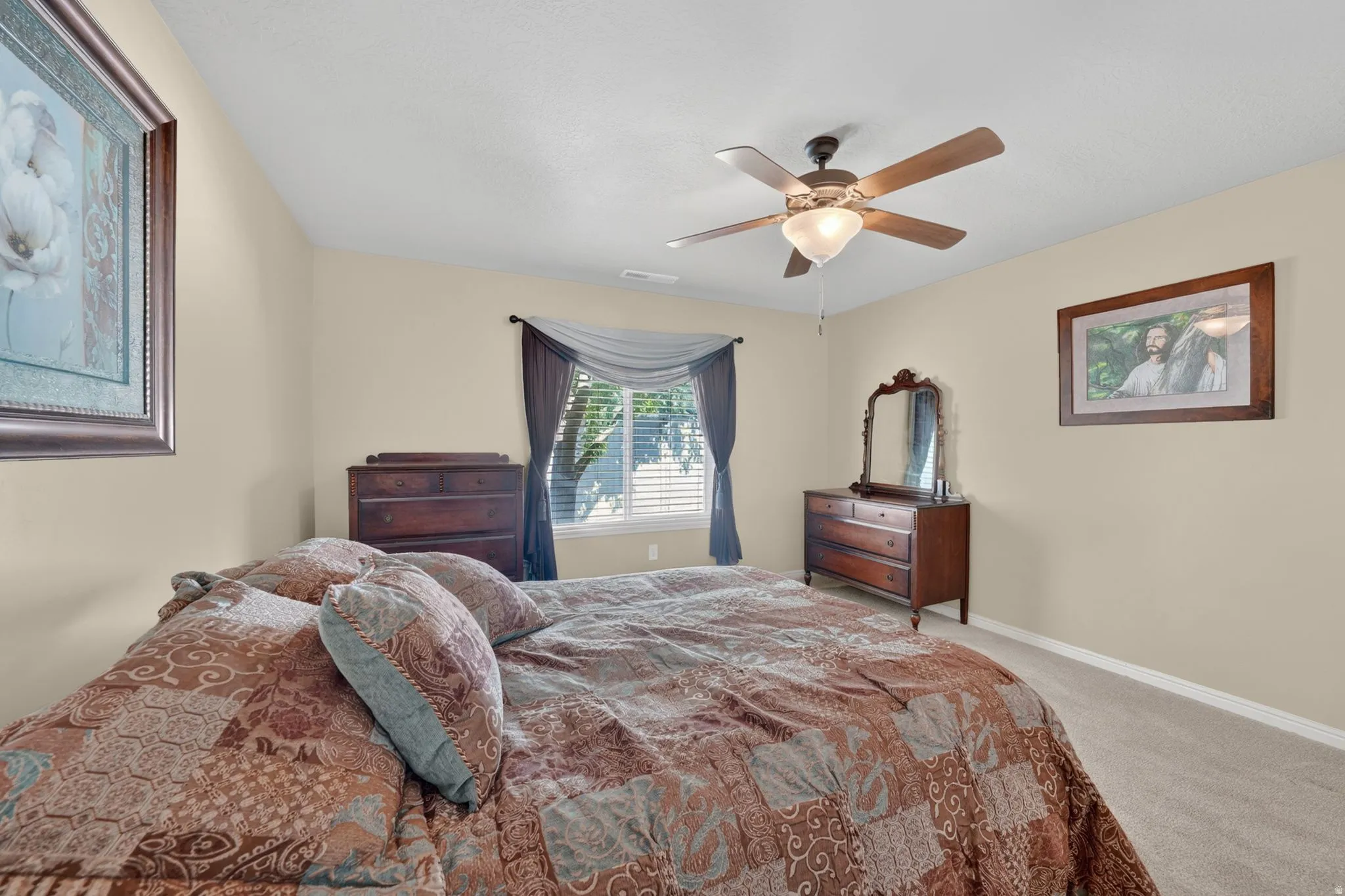 Carpeted room with a ceiling fan light fixture