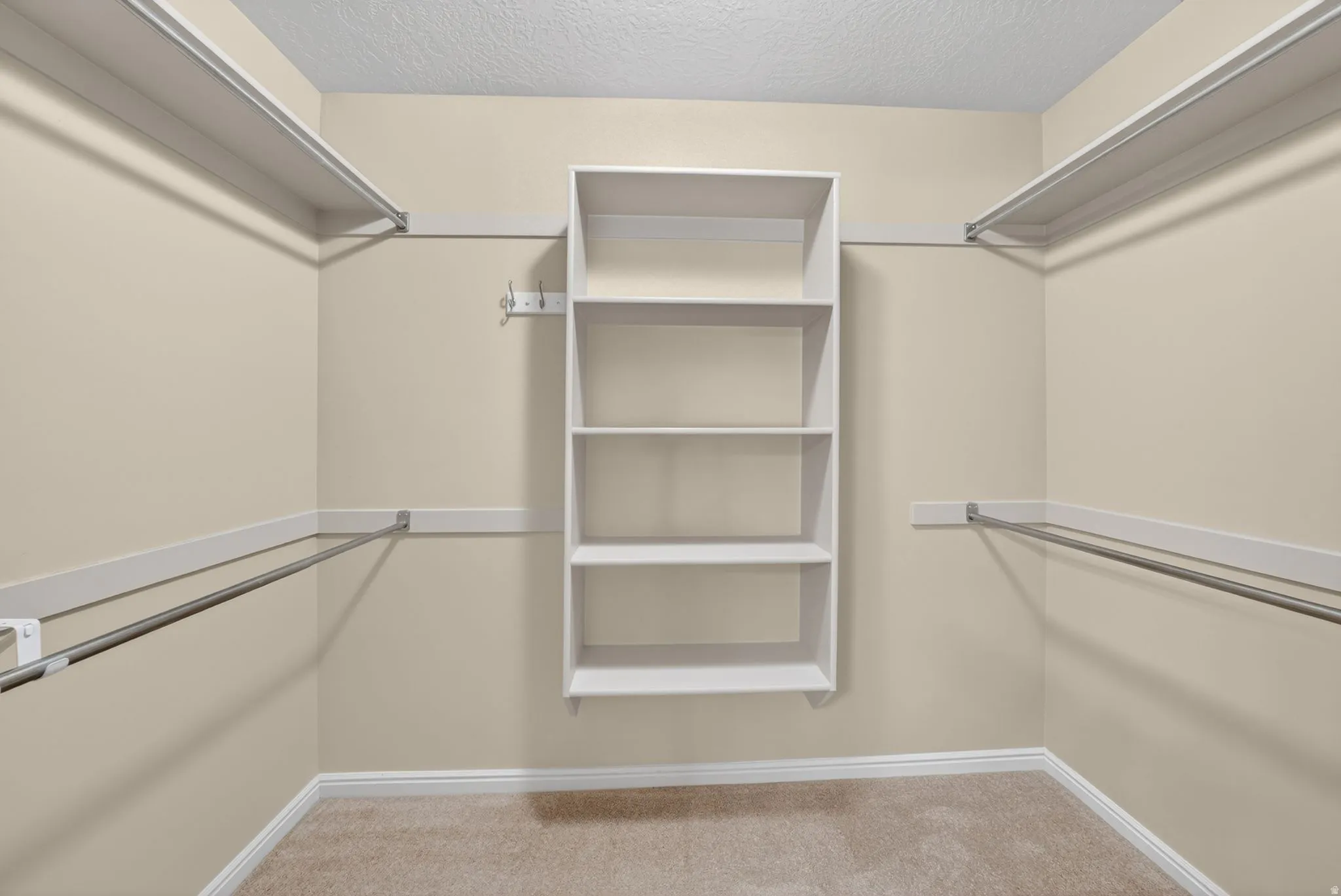 Walk-in closet featuring built-in shelving, chrome hanging rods, neutral wall tones, and carpet flooring