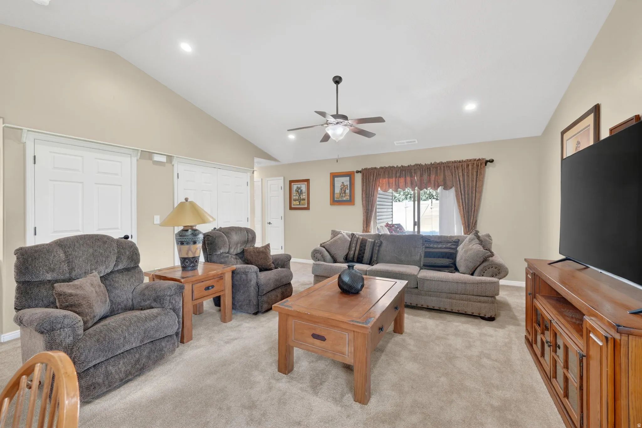 Living space featuring vaulted ceilings, recessed lighting, and a ceiling fan