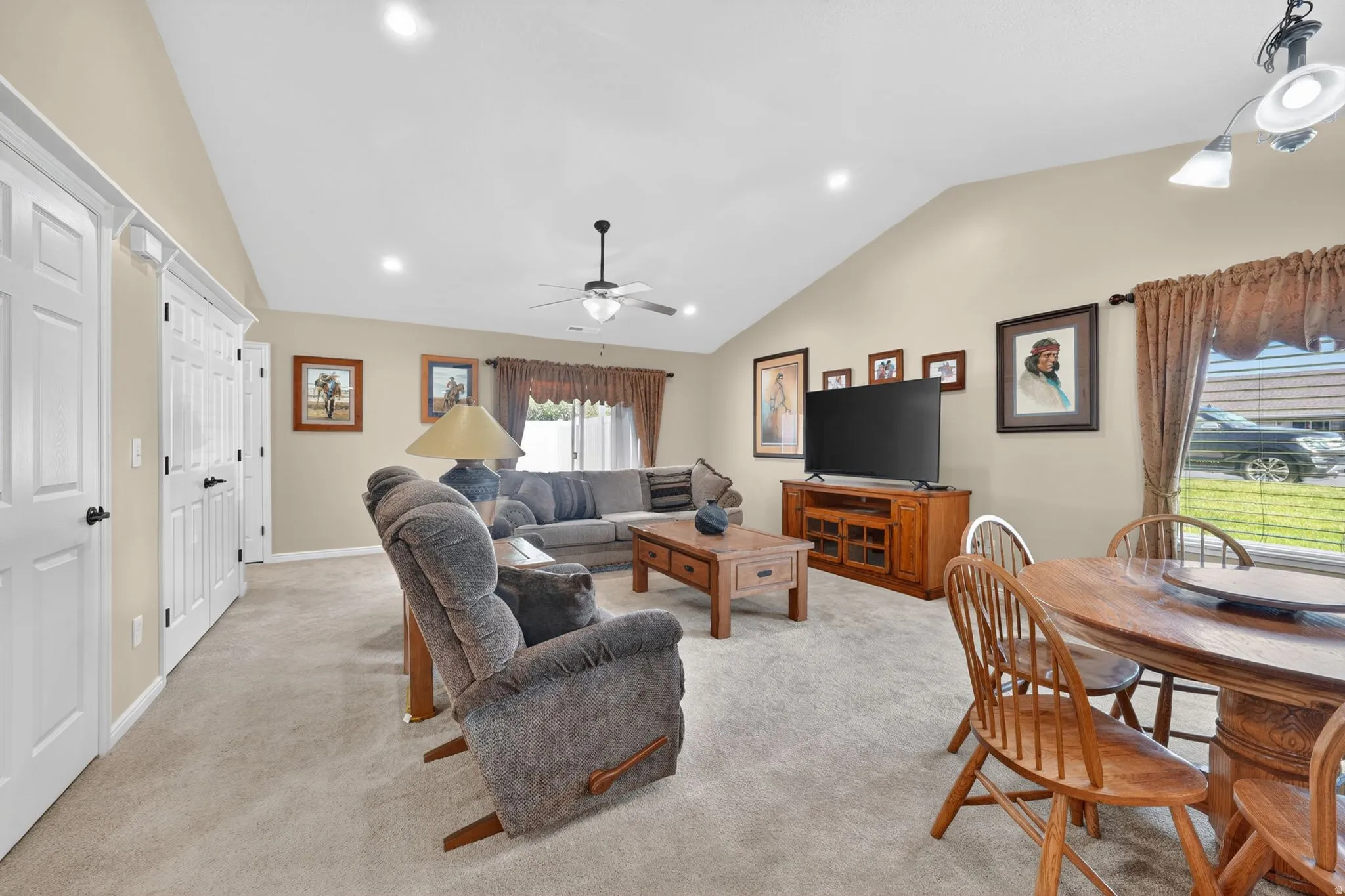 Open-concept living area with vaulted ceiling, recessed lighting, ceiling fan, and light-toned carpeting
