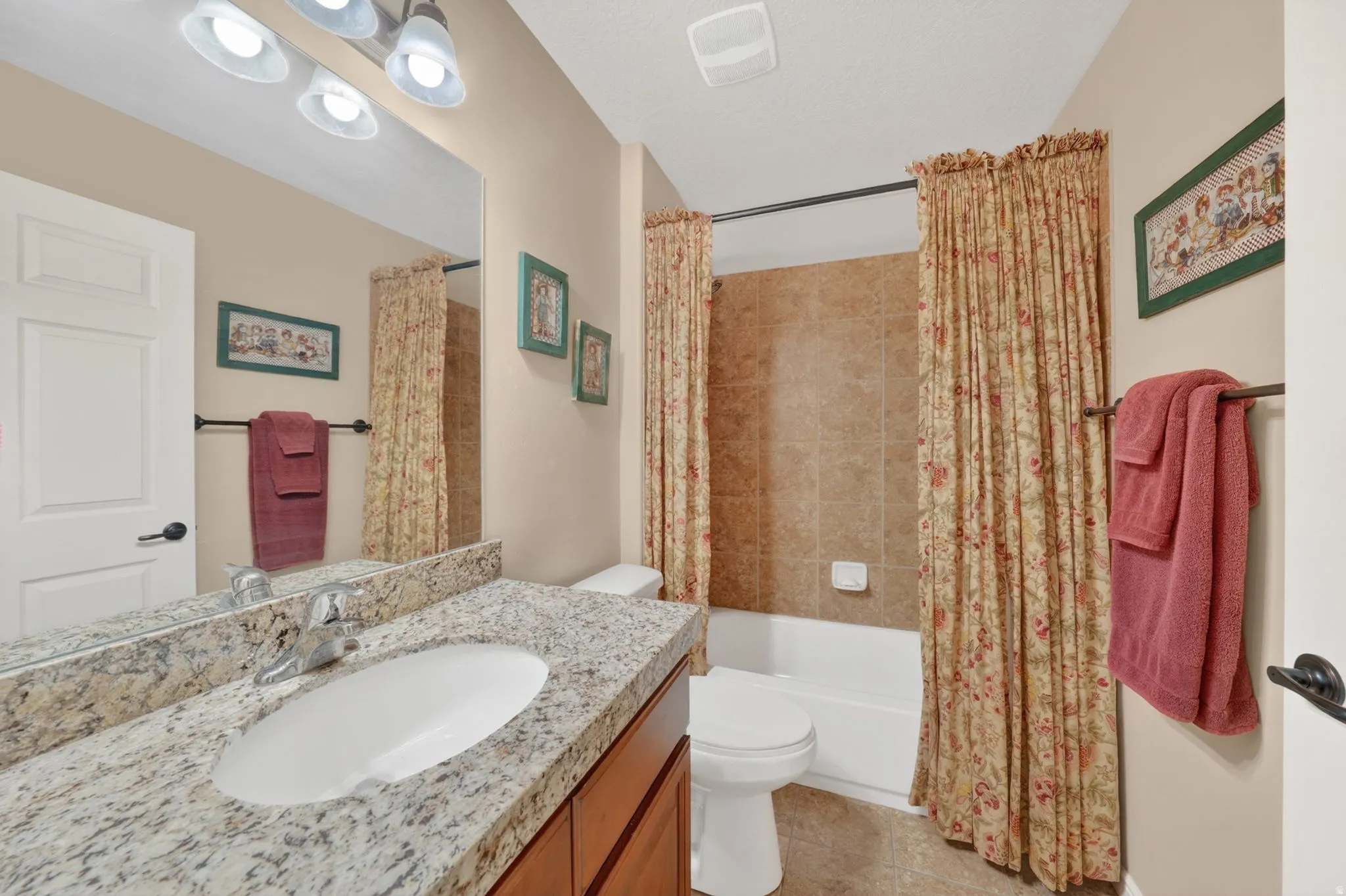 Bathroom with a single vanity featuring a stone countertop and an undermount sink