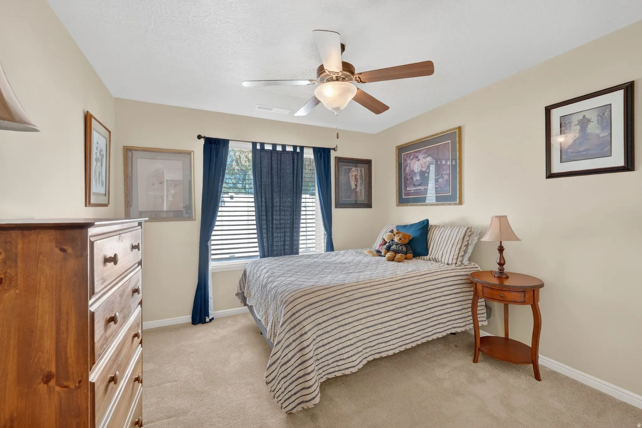 Neutral tone wall paint, textured ceiling, and light-colored carpeting