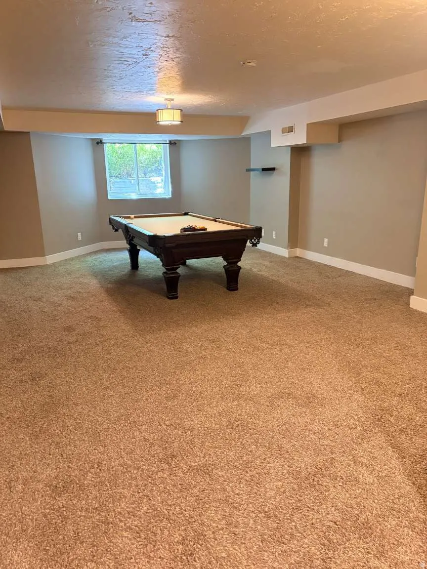 Spacious room featuring neutral carpeting, light-toned walls, and a recessed window