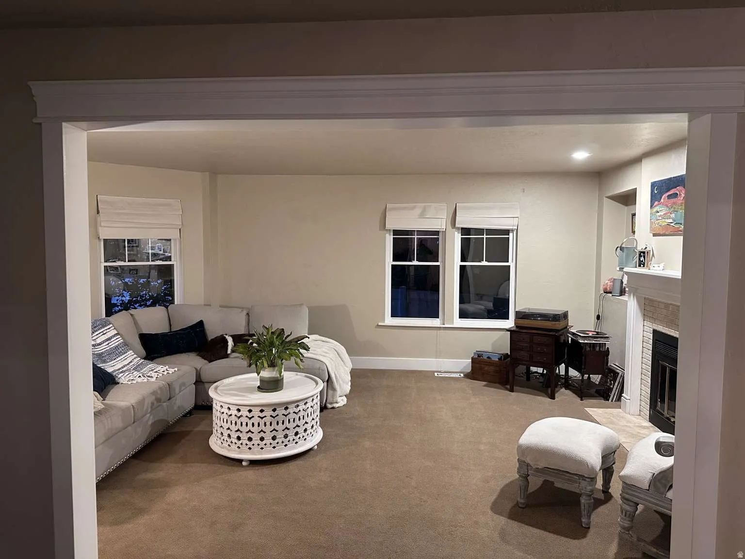Spacious living area featuring carpeted flooring, recessed lighting, and multiple windows
