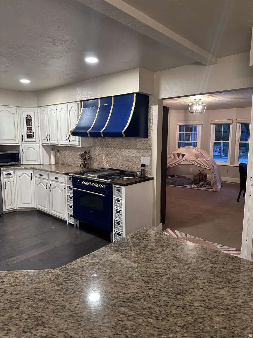 Kitchen featuring granite countertops and white cabinetry