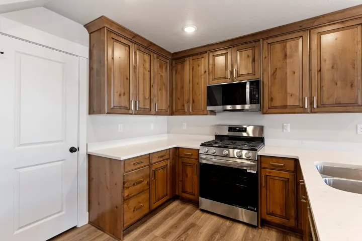 Kitchen featuring wood-finish cabinetry, white countertops, and stainless steel appliances