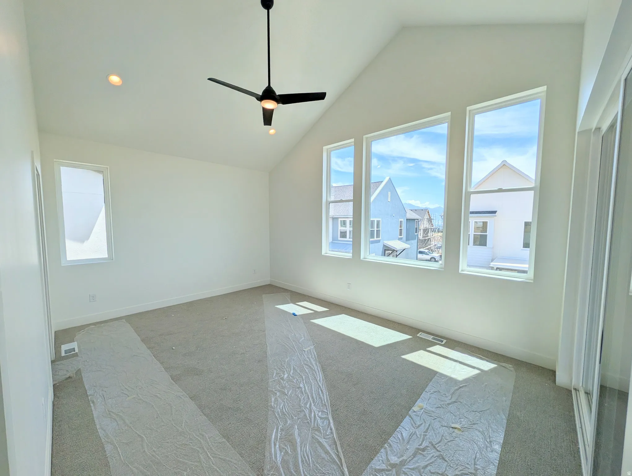 Primary bedroom- Vaulted ceiling with a contemporary ceiling fan and recessed lighting