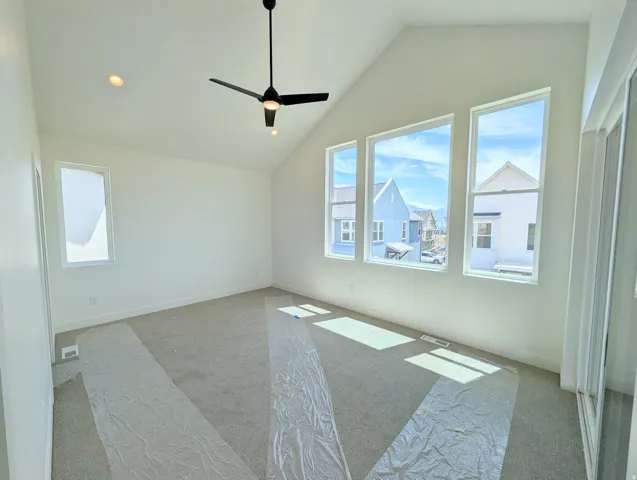 Primary bedroom- Vaulted ceiling with a contemporary ceiling fan and recessed lighting