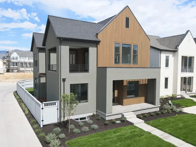 Modern exterior featuring a prominent gabled roofline with wood-finish siding and dark gray stucco