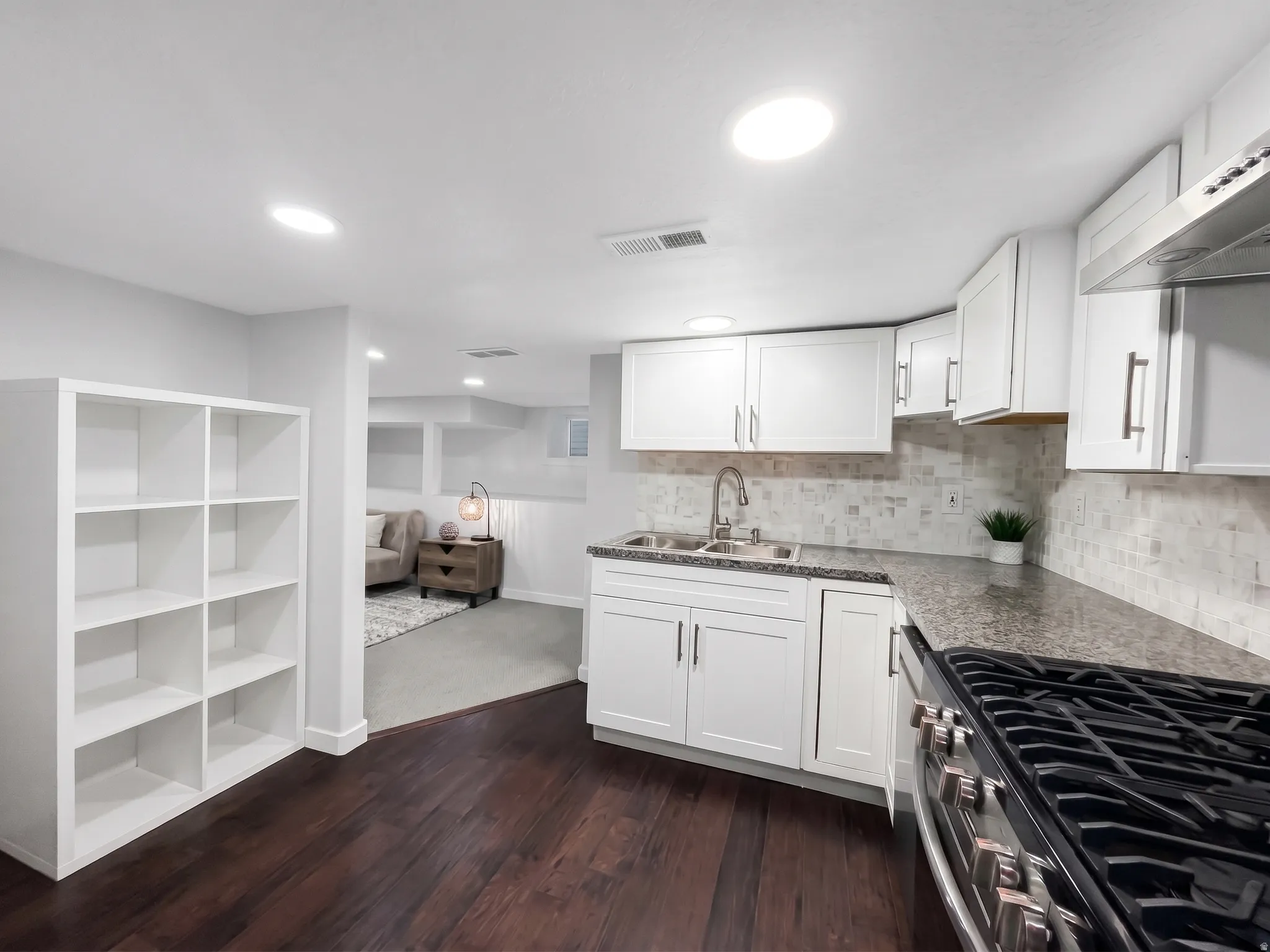 Full appliances, granite countertops, and a tile backsplash grace the second kitchen on the lower level.