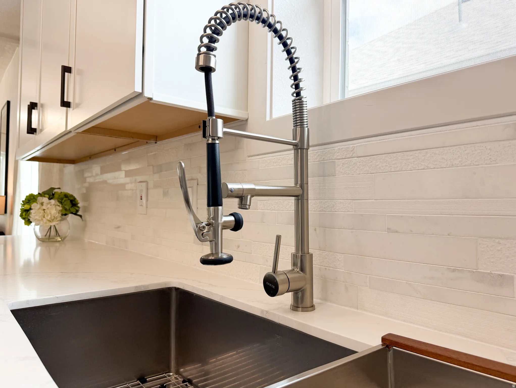 High-arc pull-down faucet, undermount sink, and quartz countertop.