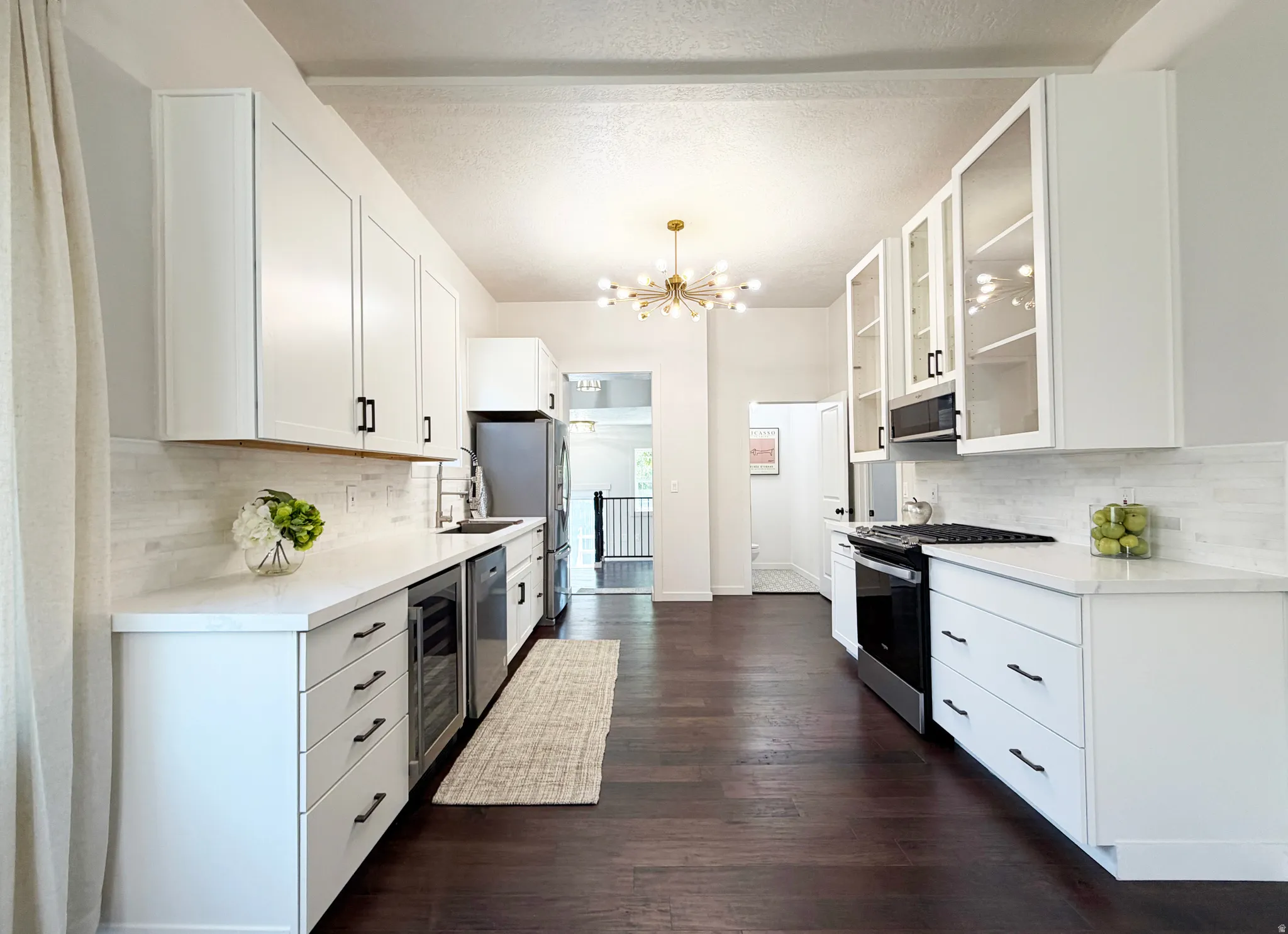 Kitchen with 10 ft ceilings, white quartz, counter-depth french-door stainless-steel refrigerator.