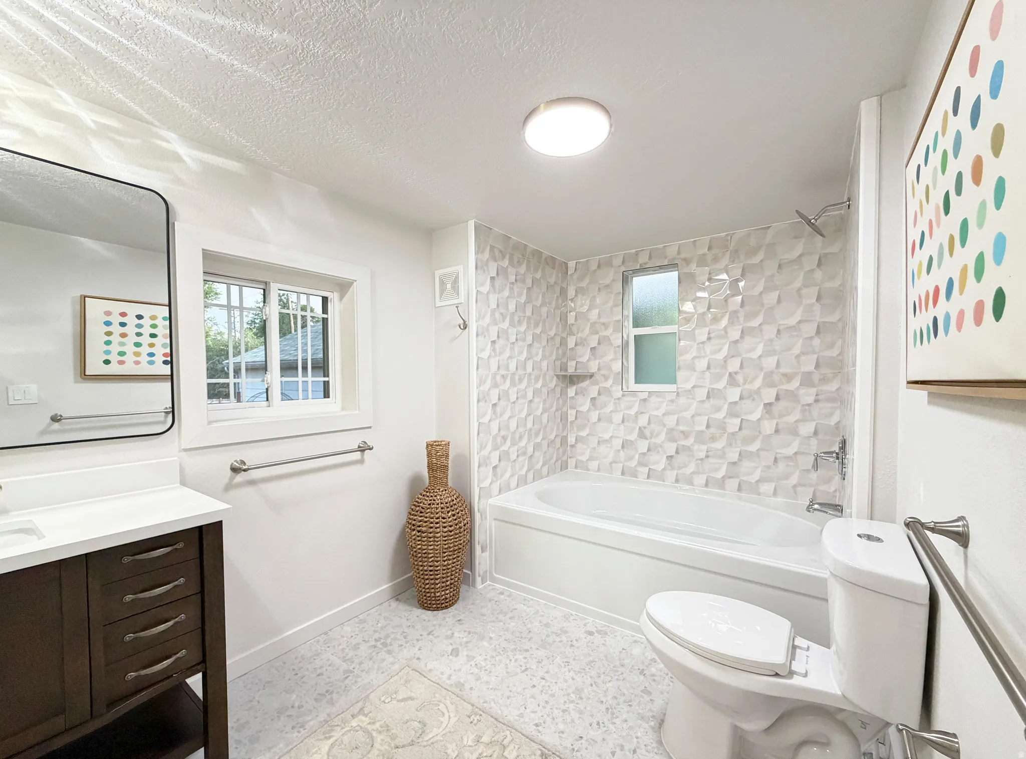 Primary bathroom with deep soaking garden tub and textured tile surround.