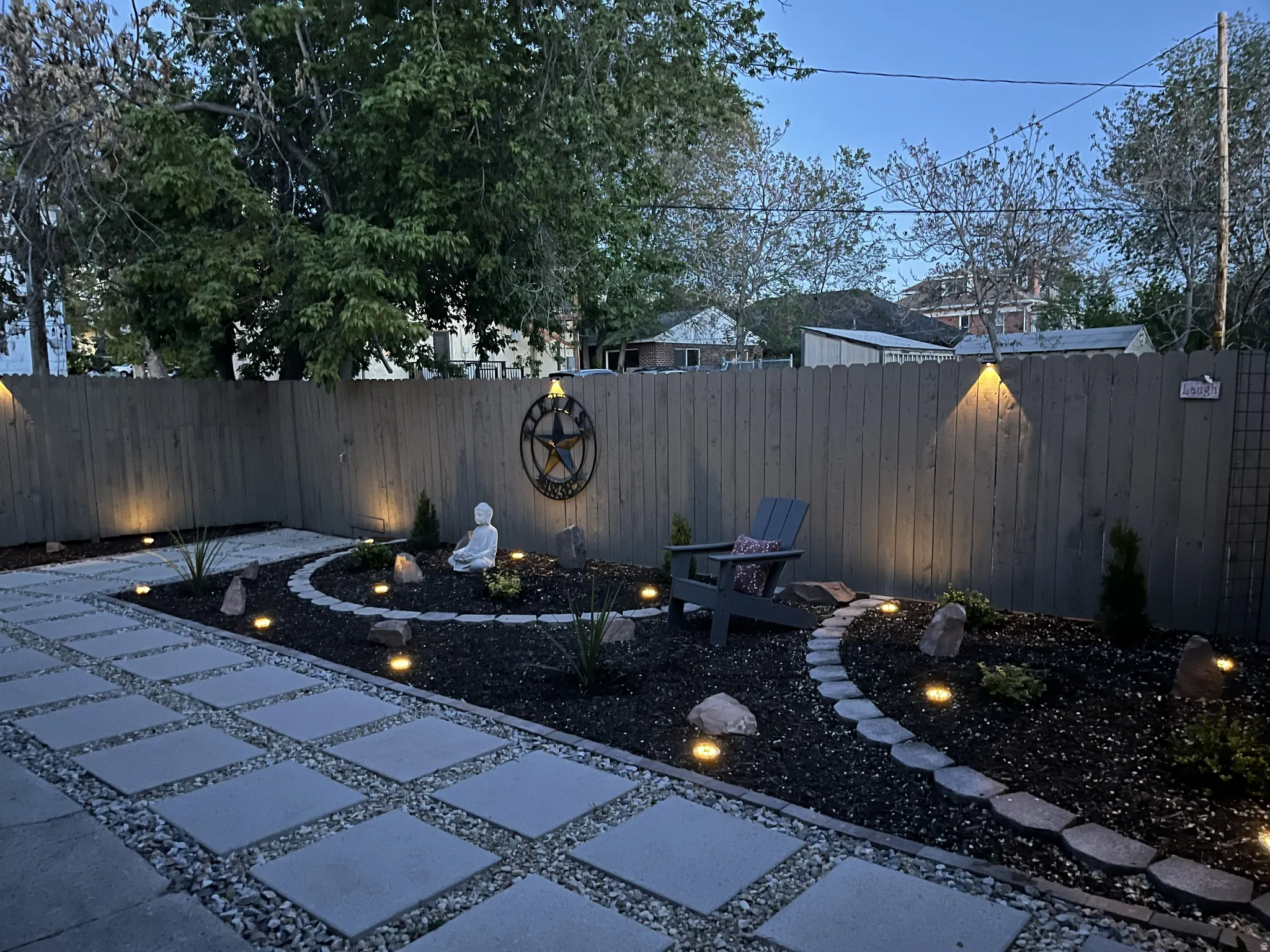 Private fully-fenced yard with solar fence lights and ground lighting.