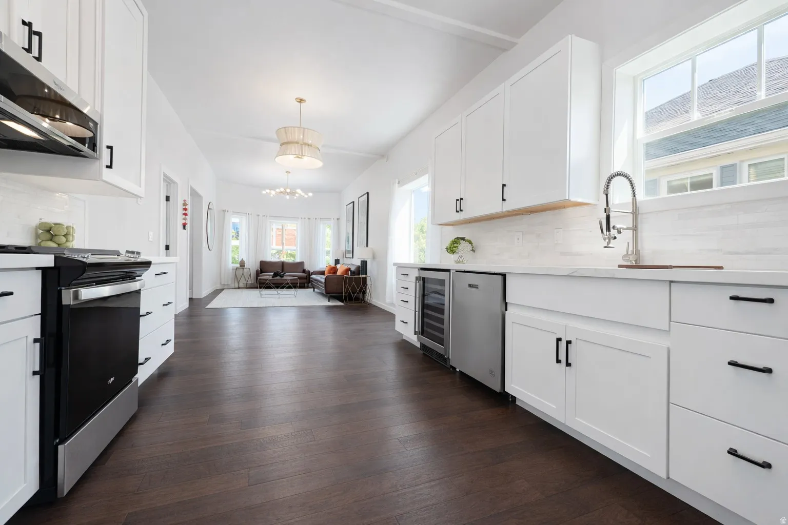 Main floor kitchen with quartz countertops, hardwood floors, new cabinetry and stainless appliances.