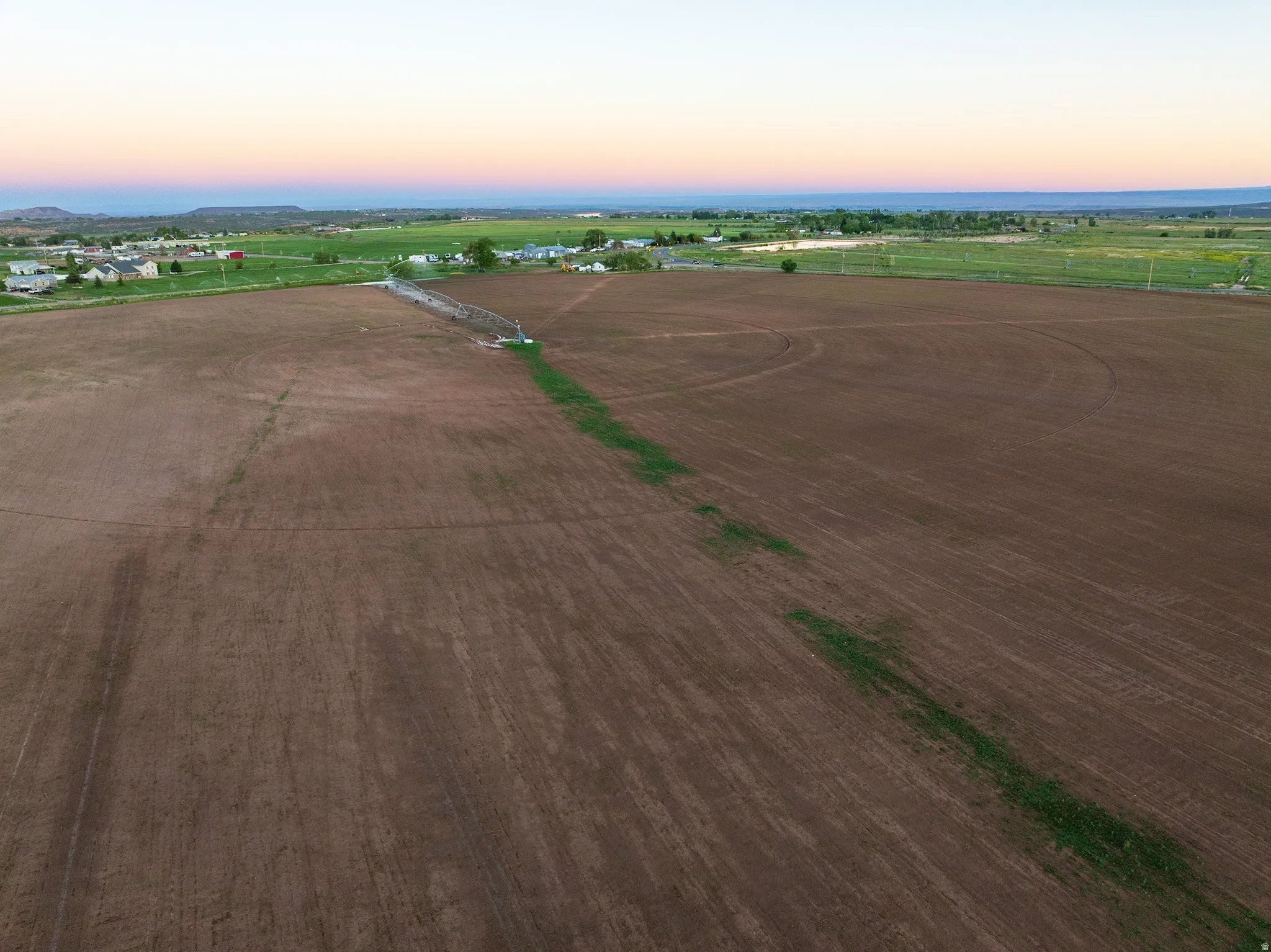 Expansive agricultural land featuring a center-pivot irrigation system
