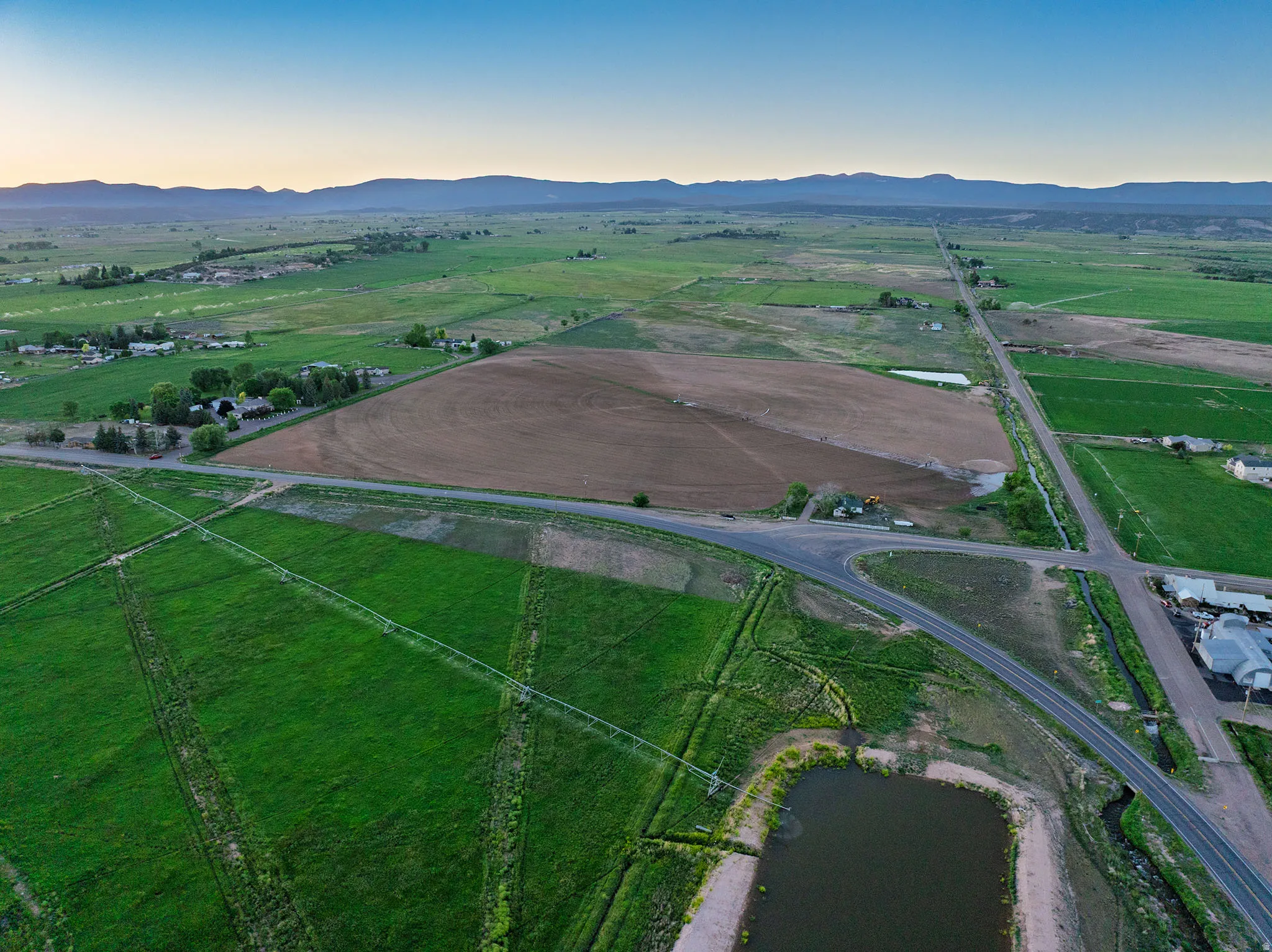 Expansive agricultural property featuring cultivated fields and verdant green pastures