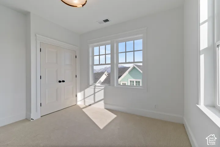 White double doors, two multi-pane windows, and neutral carpet