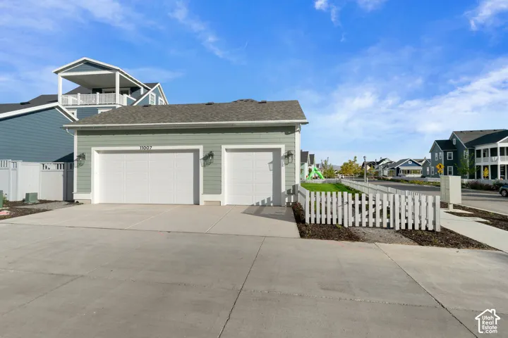 Two-car garage with white panel doors and exterior sconce lighting