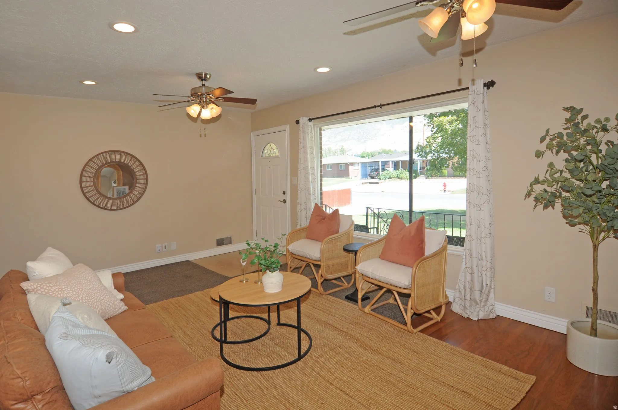 Recessed lighting, wood-finish flooring, ceiling fans with integrated lighting, and a large window with exterior visibility