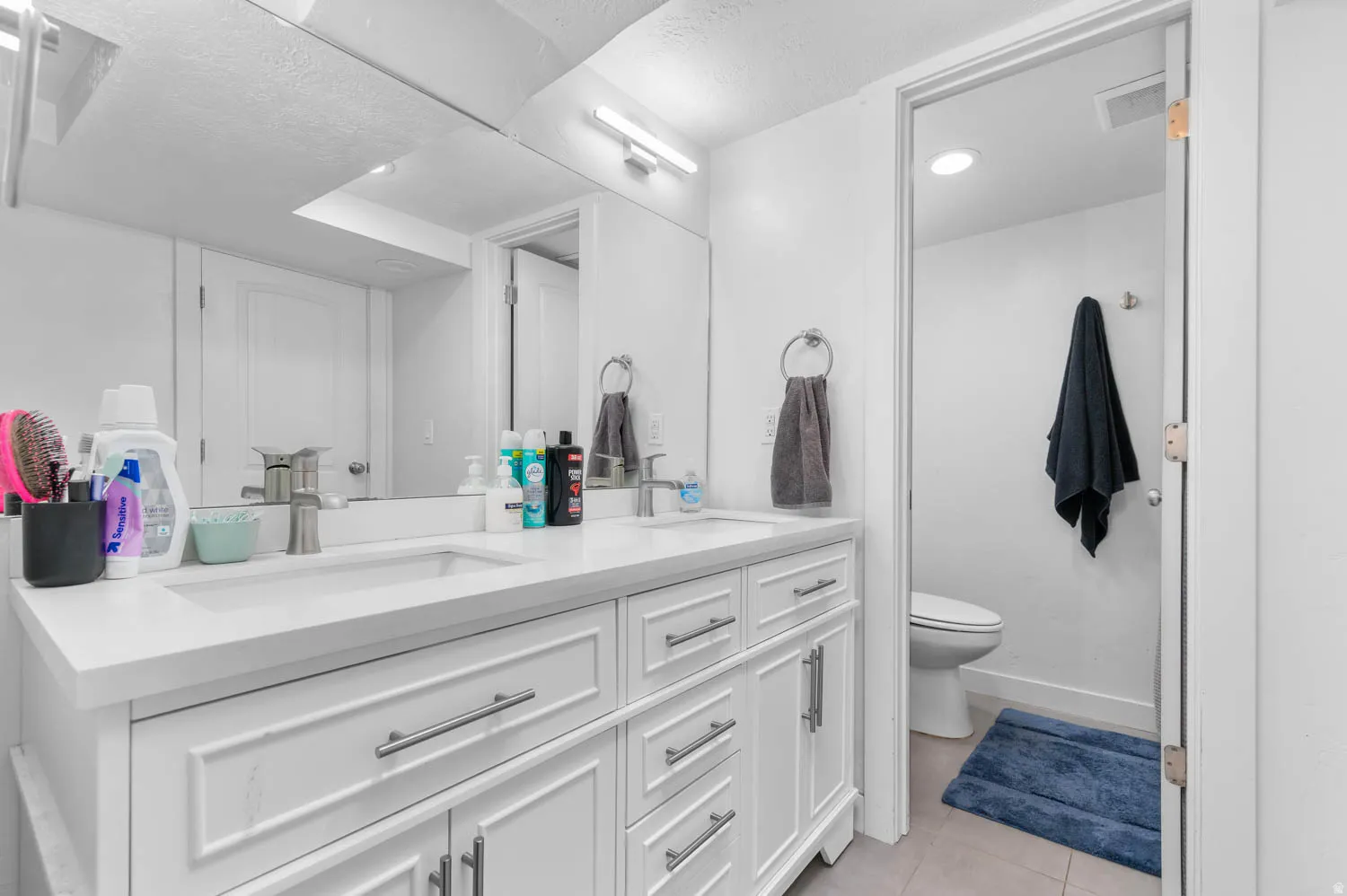 Dual vanity with white cabinetry and integrated sinks