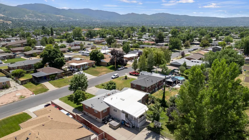 Residential neighborhood with mature trees and mountain backdrop