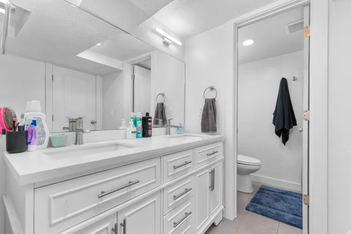 Dual vanity with white cabinetry and integrated sinks