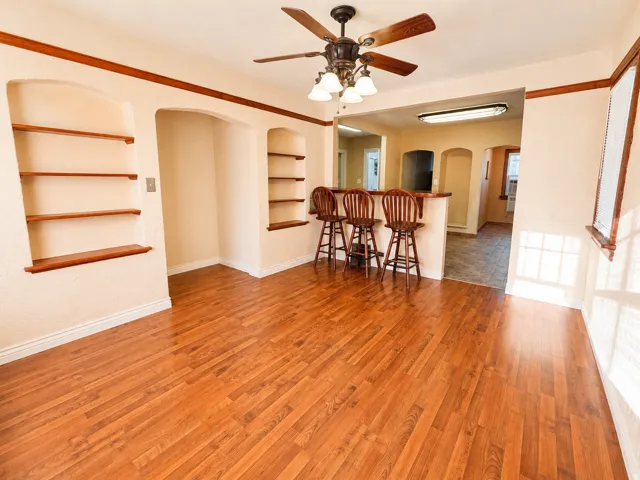 Spacious room featuring wood-finish flooring and integrated shelving