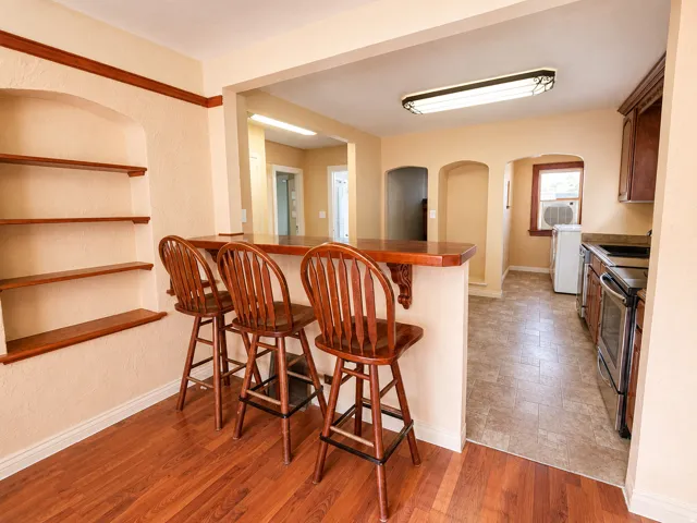 Wood-finish flooring complementing a built-in breakfast bar with a wood countertop