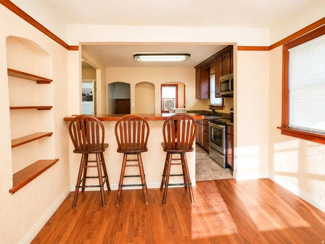 Hardwood-style flooring throughout the dining area, featuring an arched built-in shelving unit