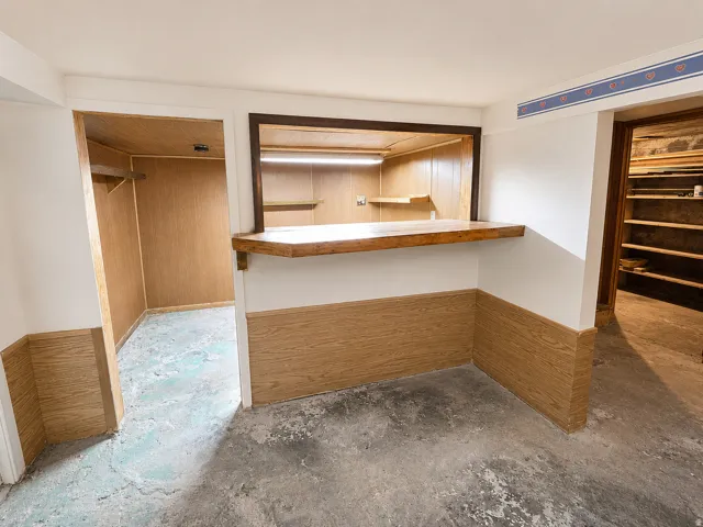 Basement area featuring a pass-through opening with a wood counter