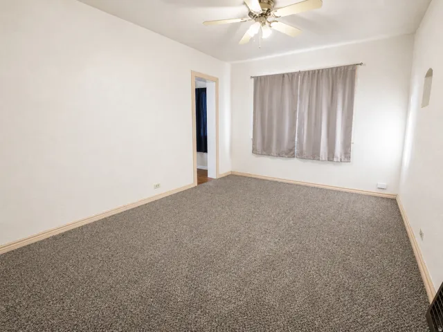 Spacious room featuring neutral carpeting and white painted walls