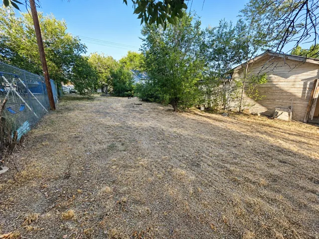 Expansive lot with mature perimeter trees and a chain-link fence