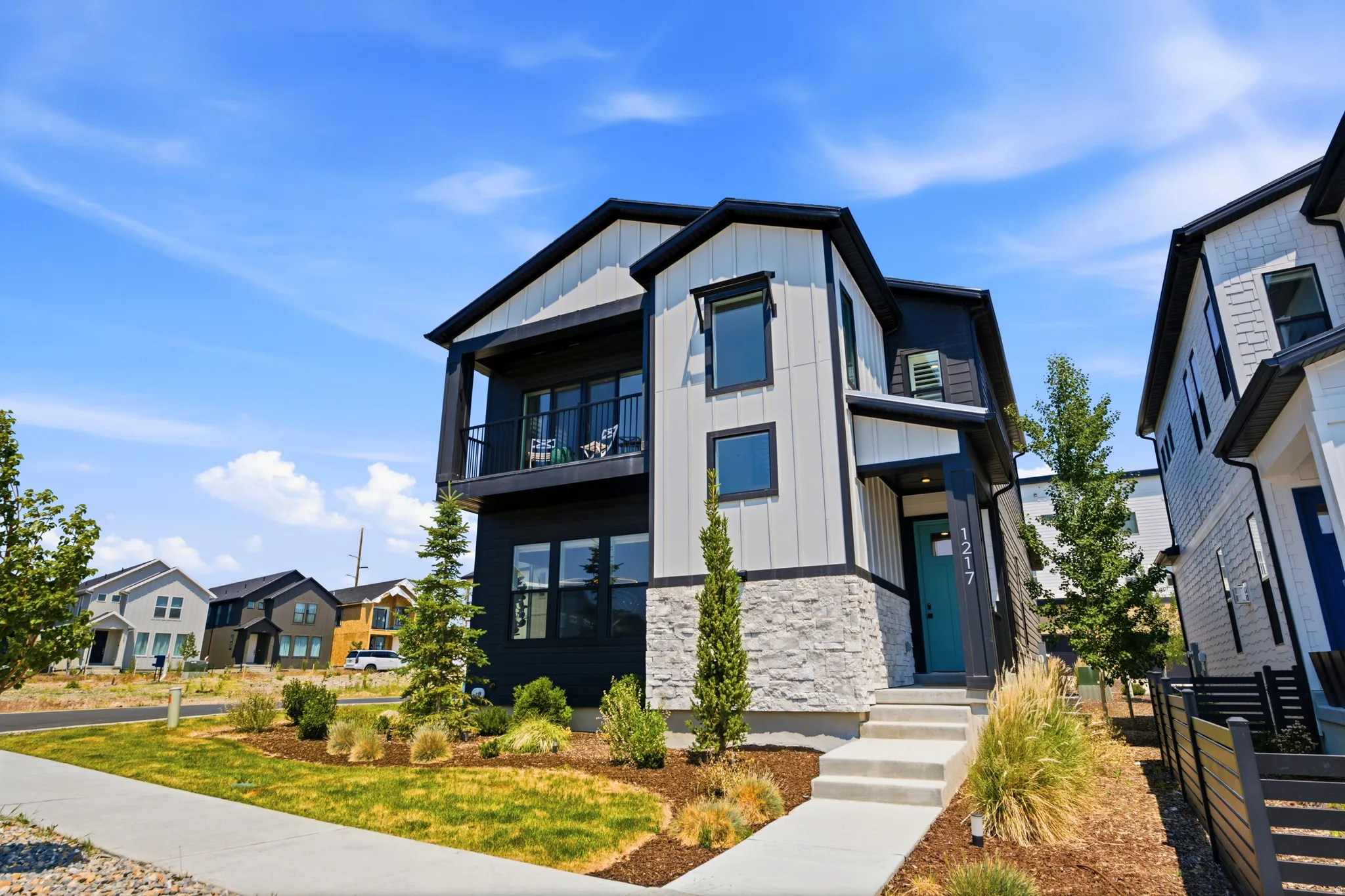 Contemporary exterior featuring board and batten siding, stone veneer accents, and a contrasting dark trim