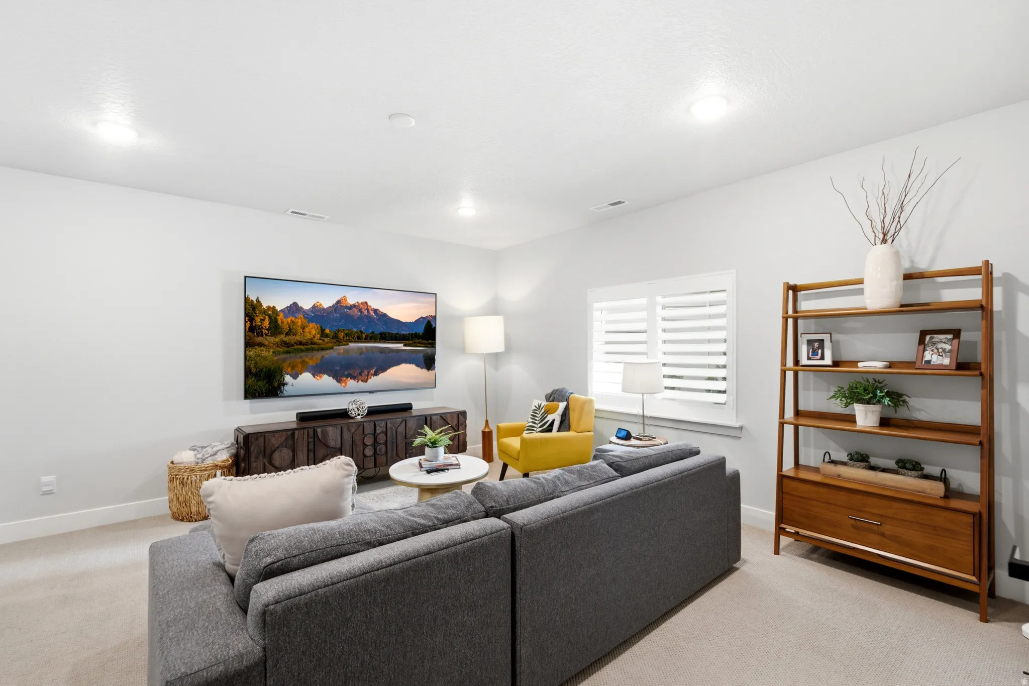 Inviting living space featuring light neutral wall paint, recessed lighting, and soft carpeting