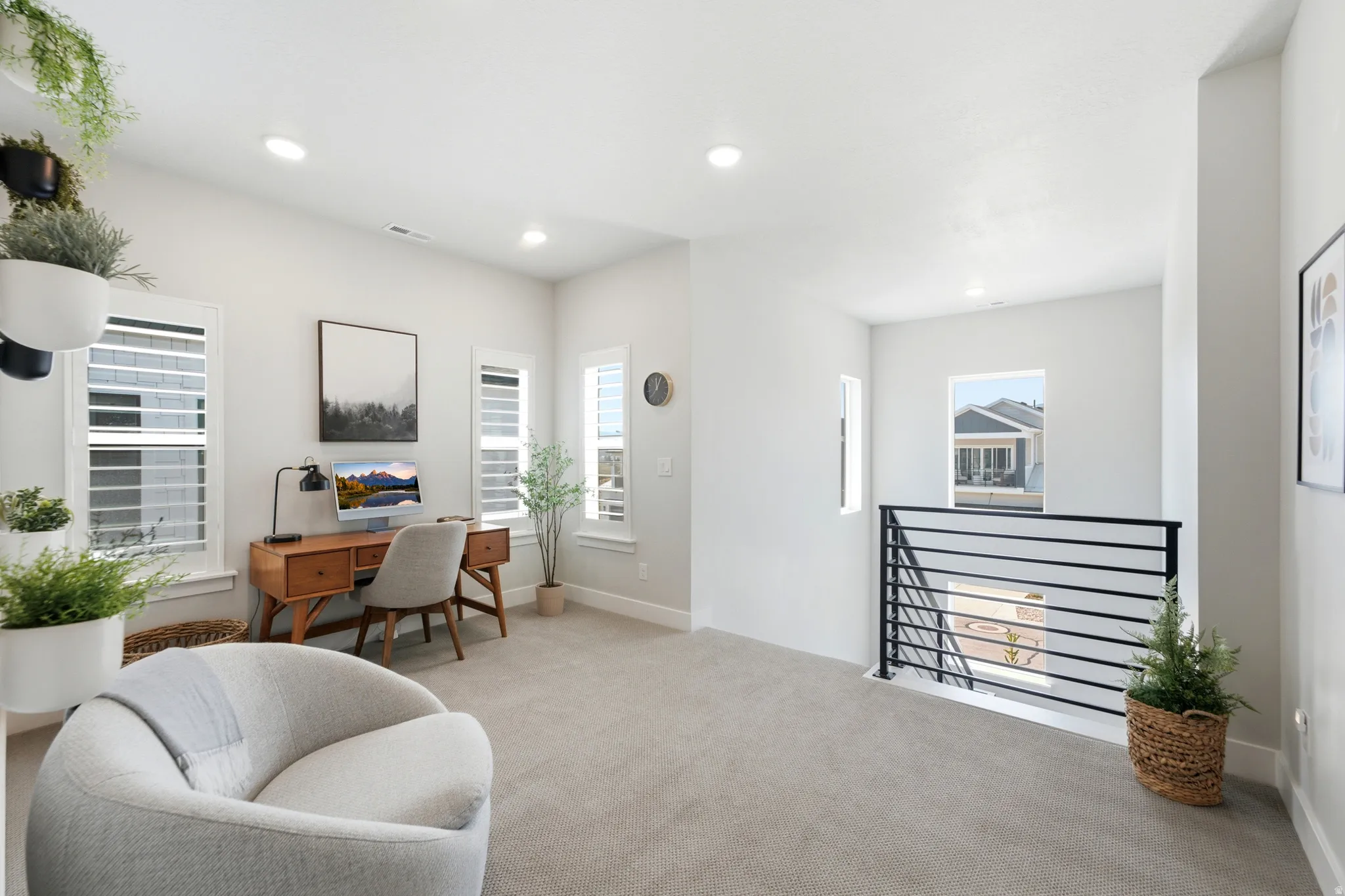Versatile loft space featuring recessed lighting, light gray carpet, and multiple windows with white plantation shutters
