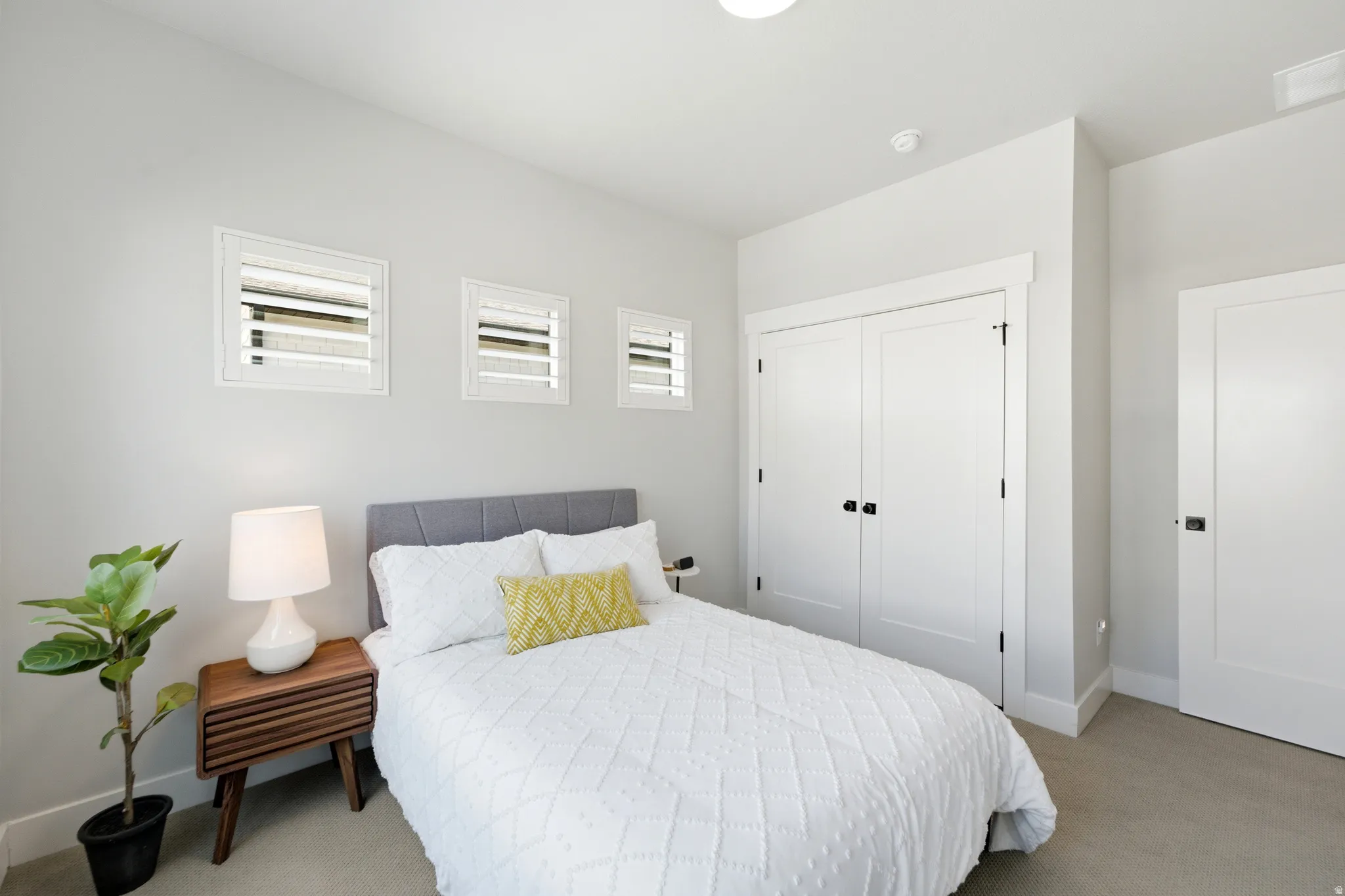 Bedroom featuring light gray walls, white trim, and light-colored carpet