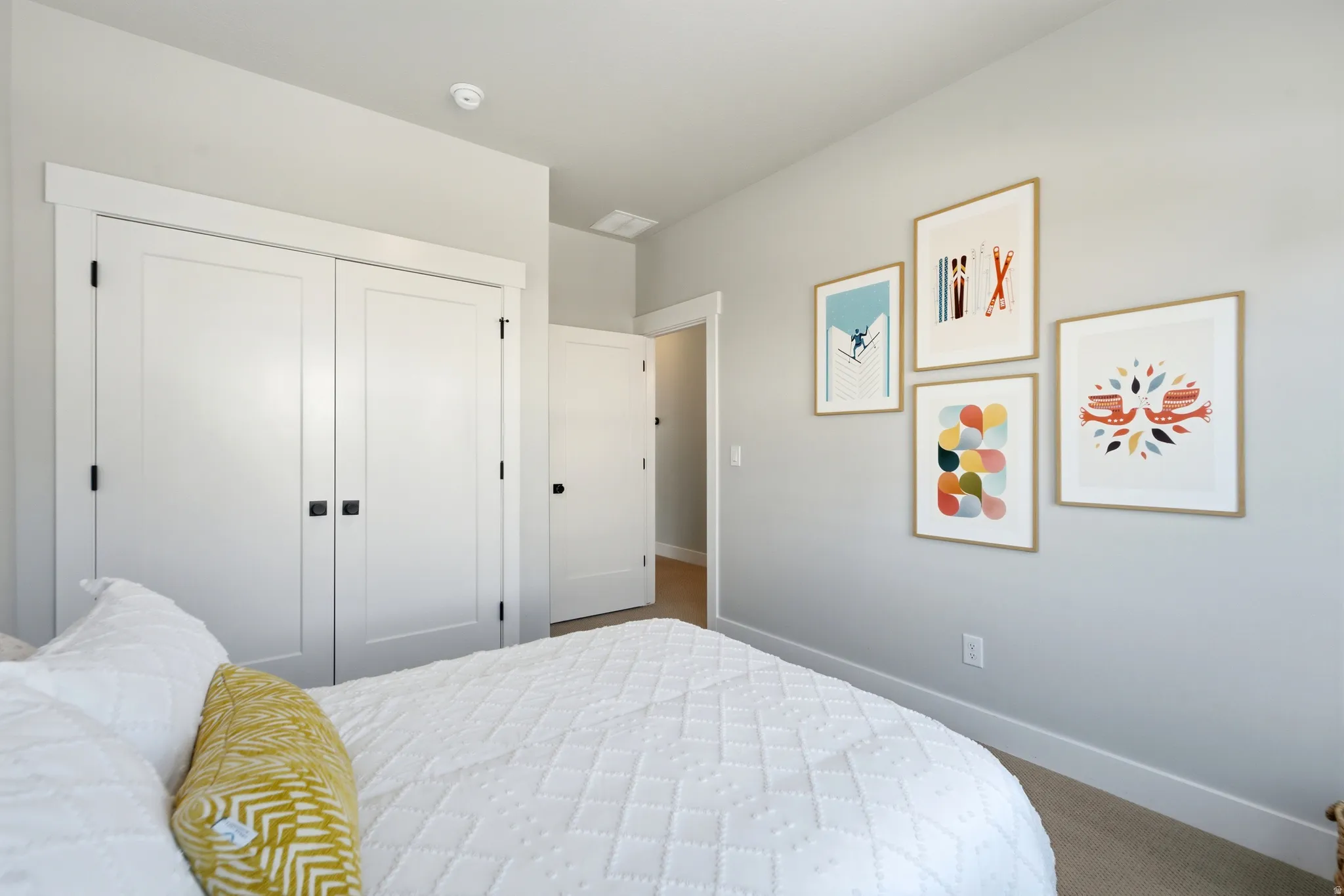 Room featuring a built-in closet with white paneled bifold doors and matte black hardware