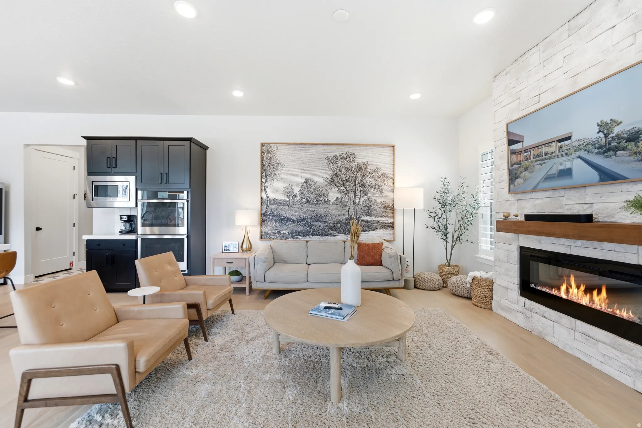 Living area featuring a floor-to-ceiling stacked stone fireplace with a wood-finish mantel and a built-in linear electric fireplace