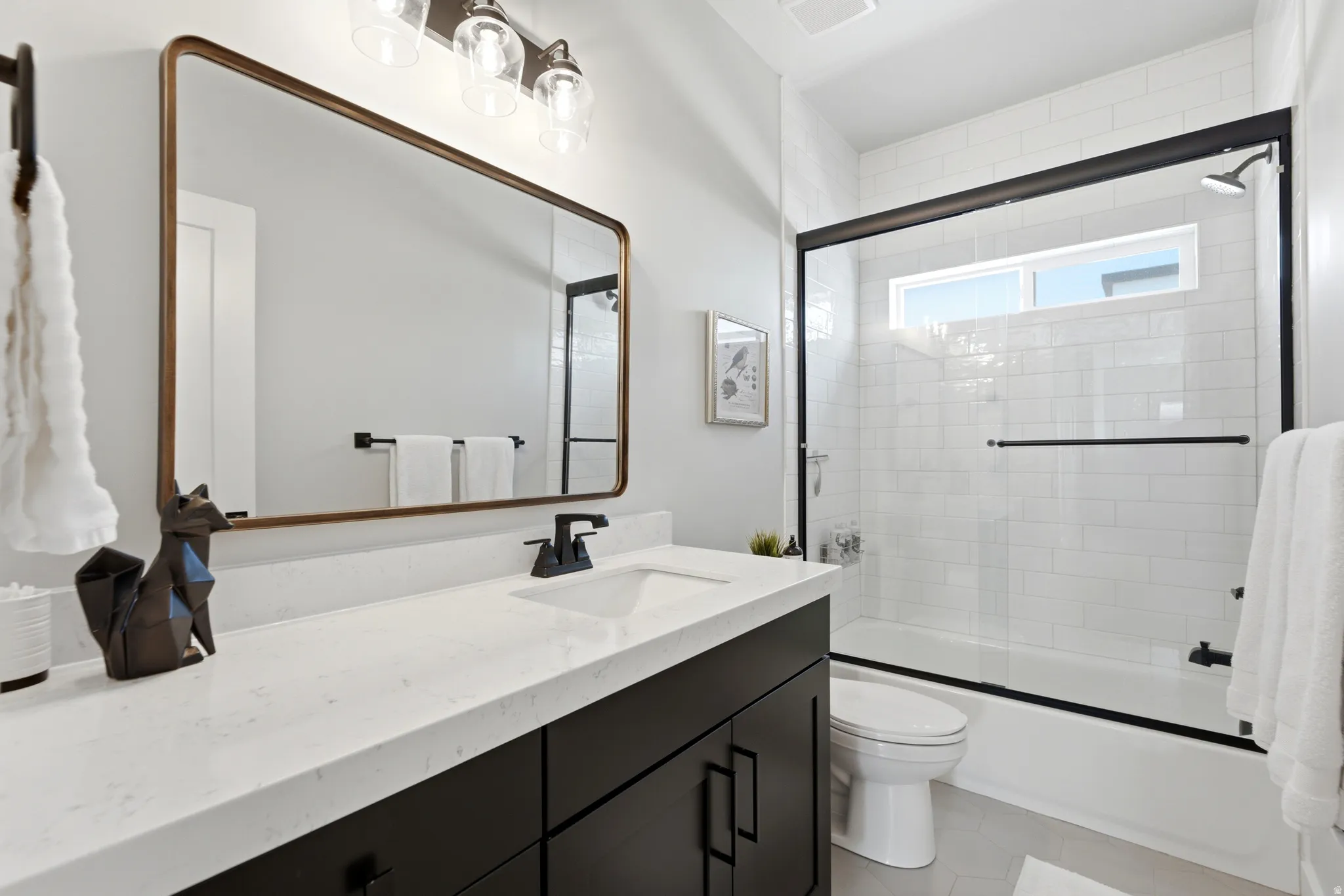 Modern bathroom featuring a single vanity with dark cabinetry, white countertop, and rectangular undermount sink