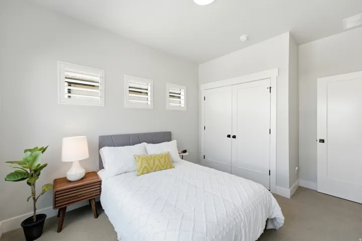 Bedroom featuring light gray walls, white trim, and light-colored carpet