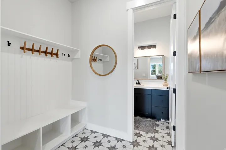 Entry area featuring a built-in bench with integrated shelving and wall-mounted coat hooks