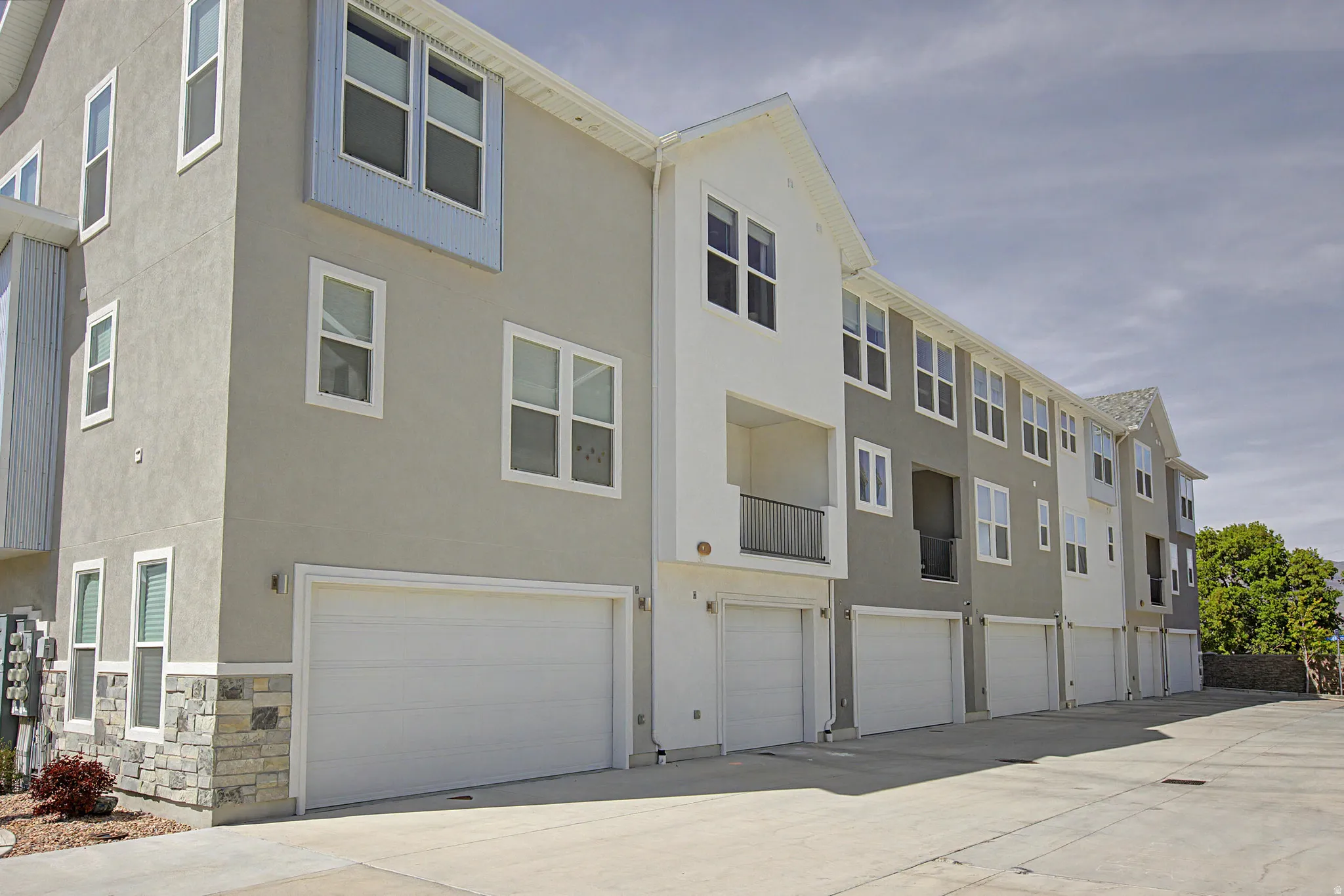 Modern multi-story building featuring stucco and stone veneer siding
