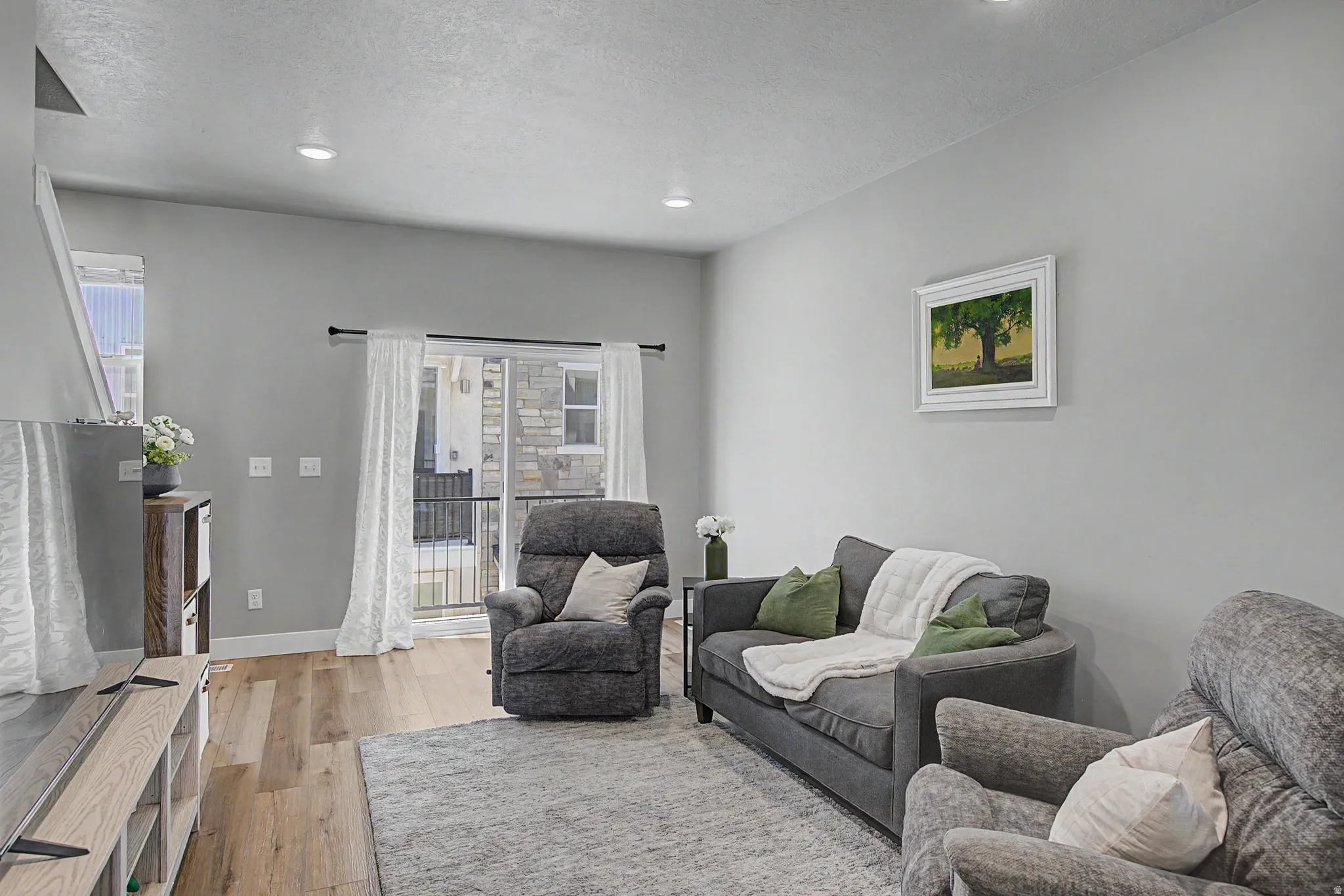 Living space featuring light gray walls and recessed lighting