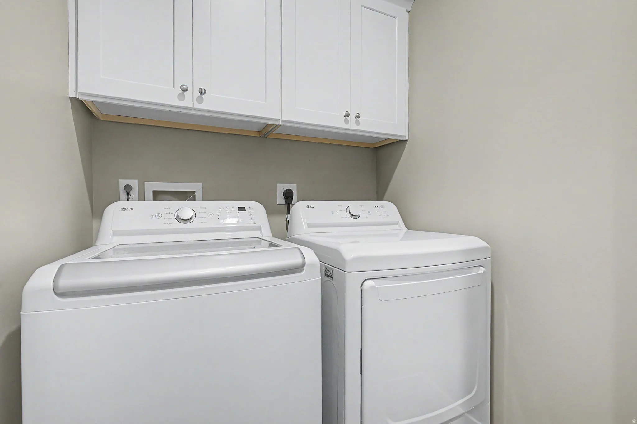 Dedicated laundry area featuring a top-load washer and front-load dryer